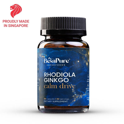 A bottle of BesaPure Rhodiola Ginkgo Calm Drive dietary supplement on a white background, featuring a blue label and a black cap, with a red 'Proudly Made in Singapore' logo in the top-left corner.